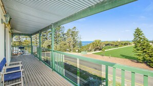 A covered balcony with a view of a coastal landscape, including a road and greenery. - Perfect Position in Port Elliot Wifi (Port Elliot)