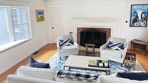 A living room with a fireplace, two armchairs, a sofa, and a coffee table.