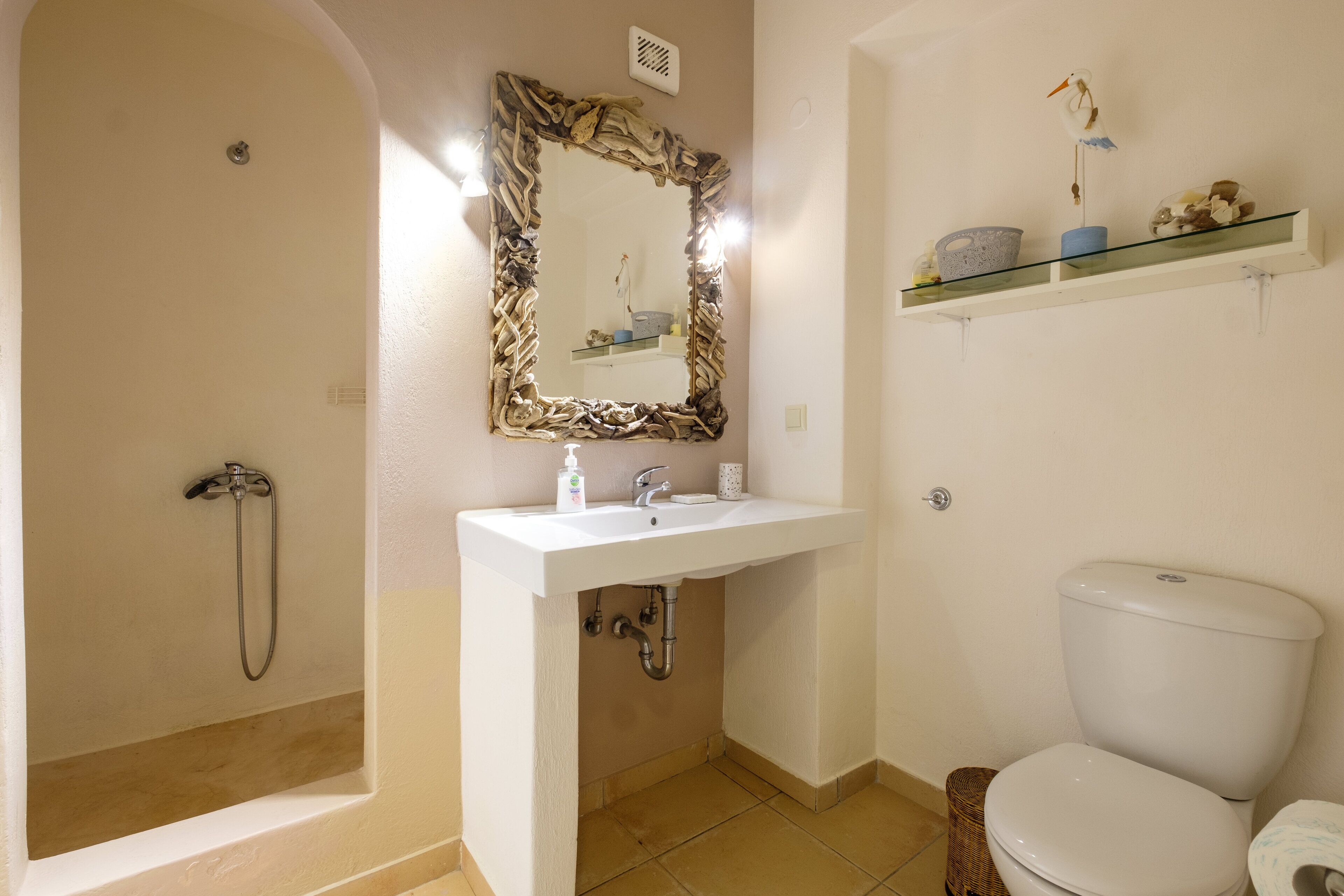 Une salle de bain équipée d’une douche, d’un lavabo, de toilettes et d’un miroir agrémenté d’un cadre décoratif.