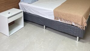 Een slaapkamer met een bed, nachtkastje en een airconditioning.