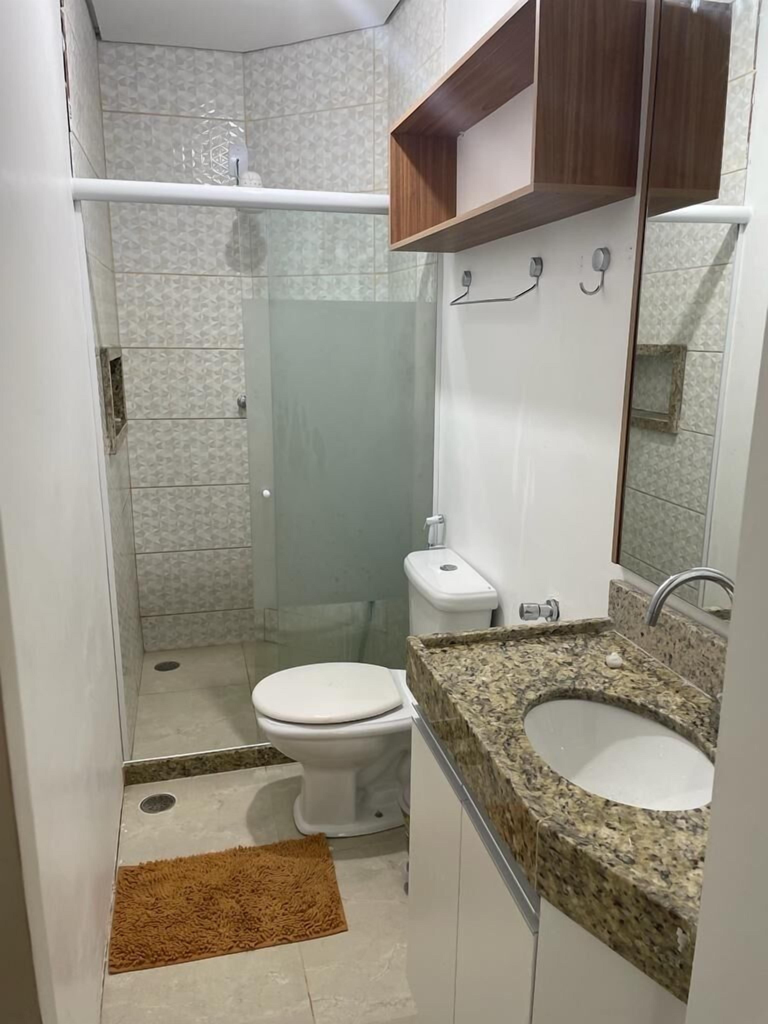 Een badkamer met toilet, wastafel en douche.