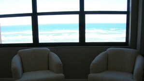 Two armchairs facing a large window with a view of the ocean. - Oceanfront - Beautiful, Direct Oceanfront. Extra Large 1 Bedroom, 1+ Bath (New Smyrna Beach)