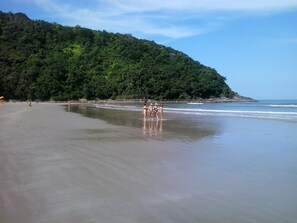 A beach with a forested hill in the background. - House with air conditioning 50m from Riviera Beach, house with Wi-Fi.  (Bertioga)