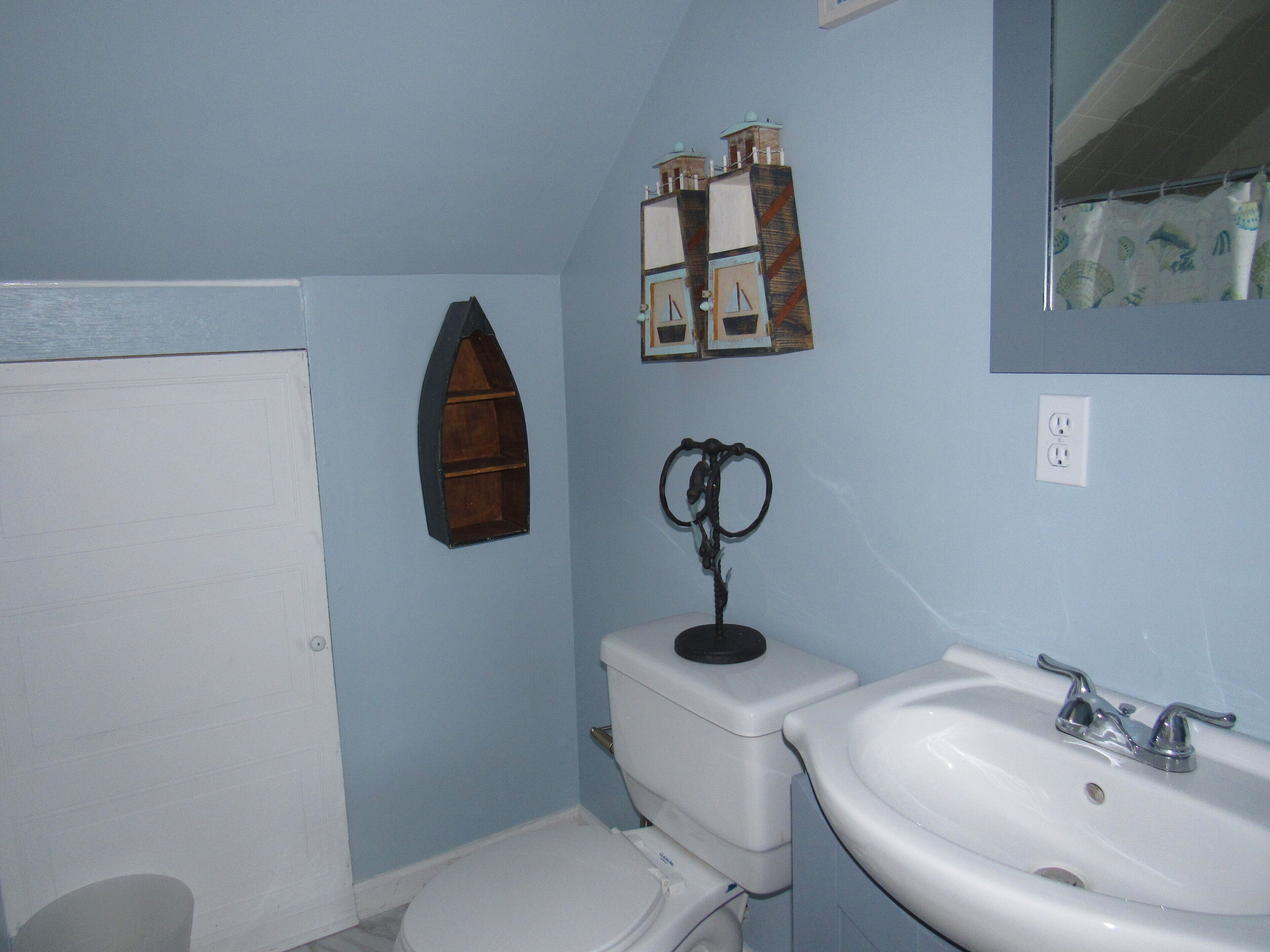 Une salle de bain équipée de toilettes, d’un lavabo et d’un miroir décoratif.