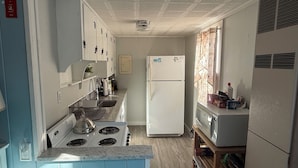 A compact kitchen with a stove, sink, and refrigerator.