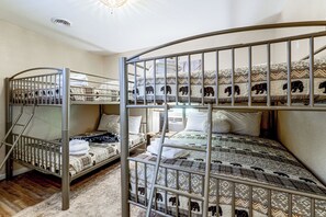 A bunk bed room with metal railings and patterned bedding. - Pool Open Until Oct 15th! ~ 1 Mi to Dollywood (Pigeon Forge)