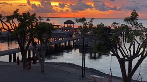 Um cais que se estende sobre águas calmas, com um pôr do sol ao fundo.