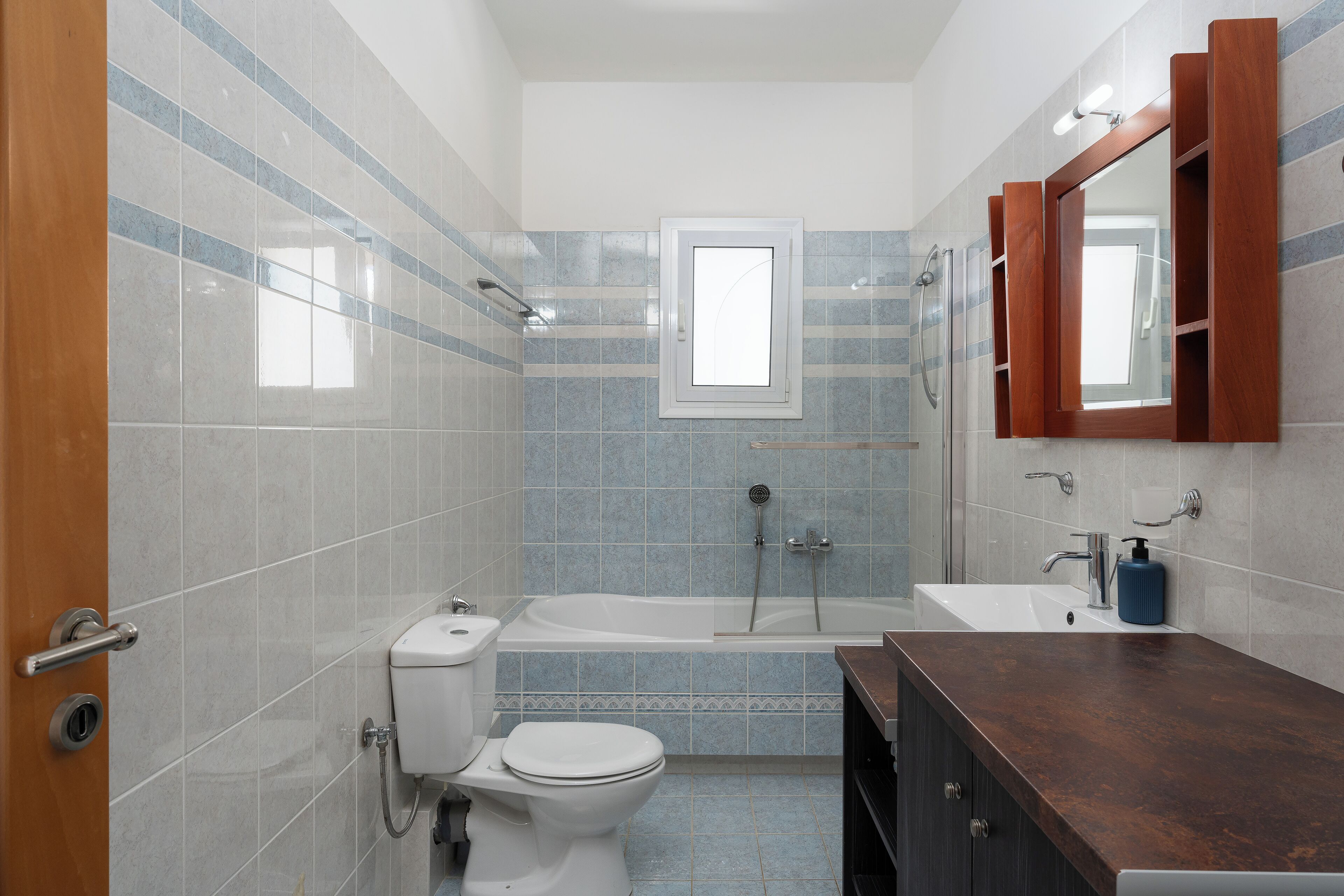 A bathroom with a toilet, sink, bathtub, and shower.