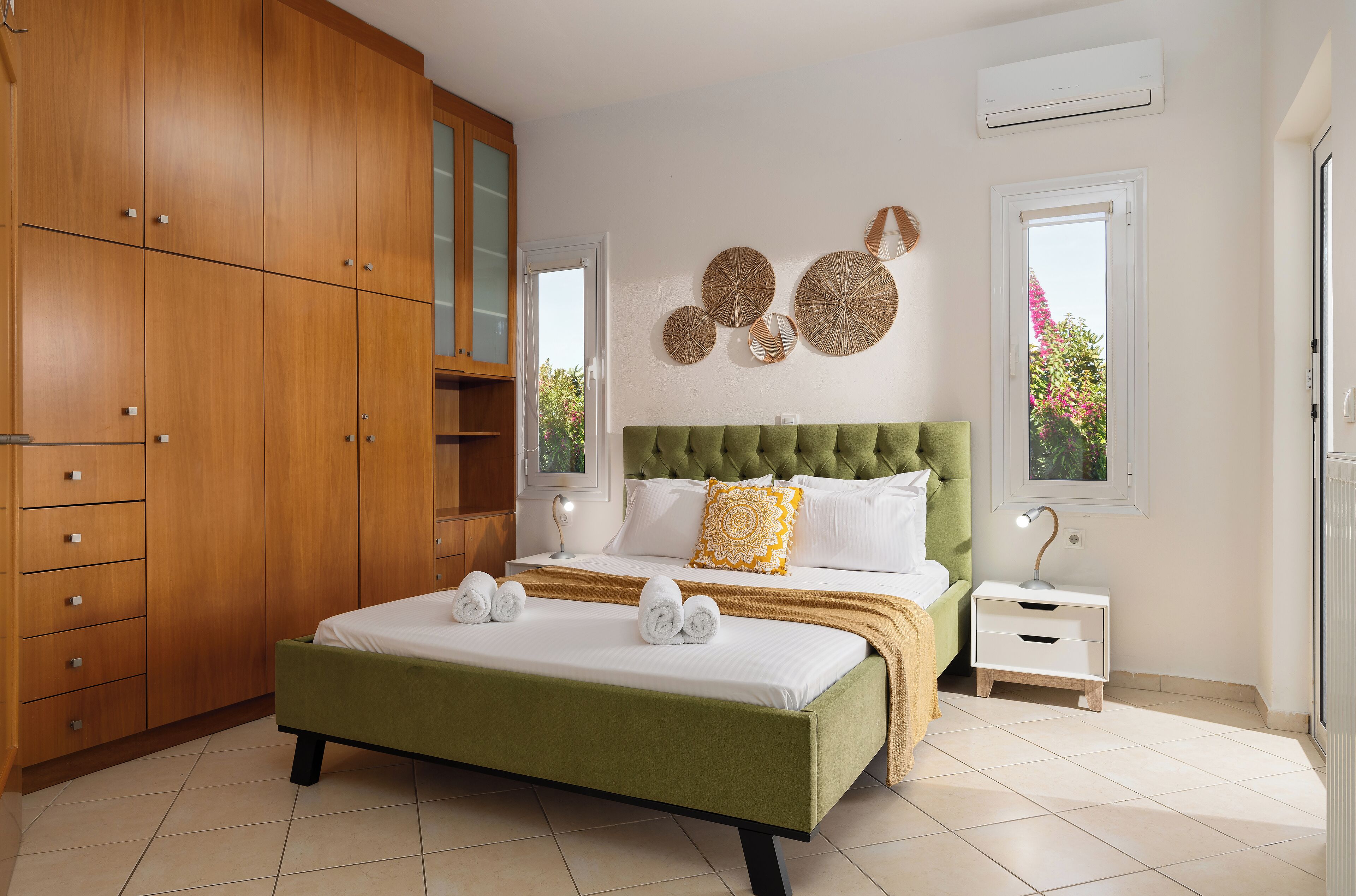 Ein Schlafzimmer mit einem großen Bett, einem Holzschrank, Nachttischen und dekorativen Wandbildern.