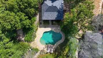 A house with a swimming pool surrounded by trees.