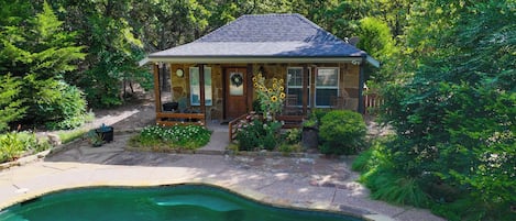 A house with a swimming pool, surrounded by trees.
