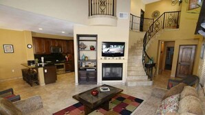 A living room with a sofa, a coffee table, a TV, and a fireplace. - Condo 57-4 El Dorado Ranch (San Felipe)