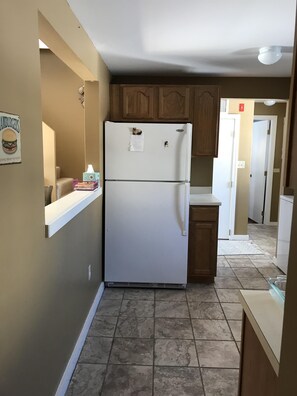 Enjoy cooking in this kitchen with a refrigerator, cabinets, and countertop.