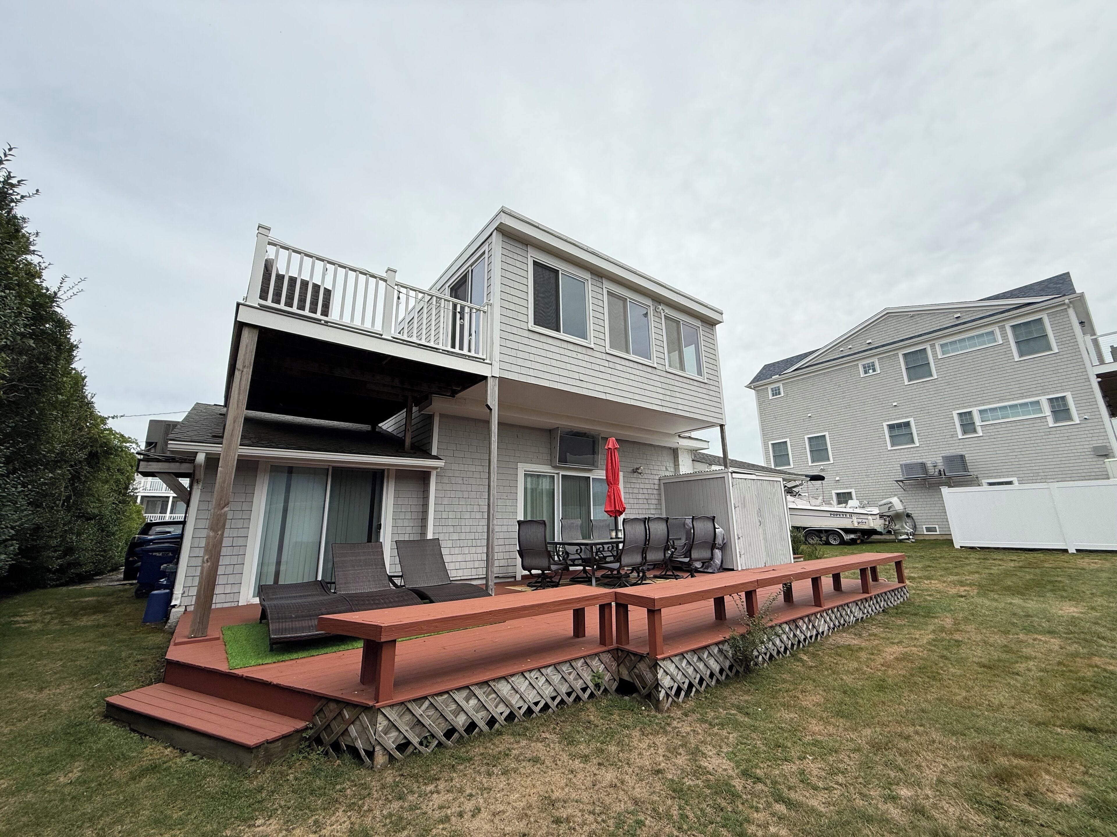 A two-story house with a balcony and a deck area.