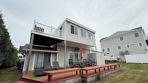 Ein zweistöckiges Haus mit Balkon und Terrassenbereich.