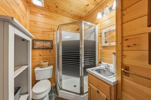 A wooden cabin bathroom with a toilet, shower, and sink. - Follow Me to Tennessee! Book now! Plan your Spring getaway! Choice dates remain! (Gatlinburg)