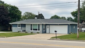 A single-story house with a garage, a front yard, and a mailbox. - Next Door To Lambeau Field /Sleeps 10+ (Green Bay)