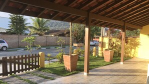 Un espace extérieur abrité, doté d’un sol carrelé, d’une clôture en bois et de plantes en pot.