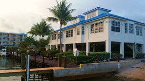 A waterfront hotel with a covered outdoor area, palm trees, and a dock. - Ocean Front Private Beach, Pool/Hot Tub, Pool Bar, Marina with Cafe (Tavernier)