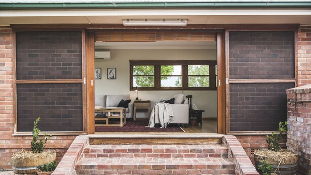 A cozy living area with a sofa, coffee table, and potted plants. - Eurunderee House - nestled in Mudgee’s famous vineyards (Eurunderee)