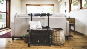 A room with a sofa set, a wooden bench, a wicker basket, and a potted plant. - Eurunderee House - nestled in Mudgee’s famous vineyards (Eurunderee)