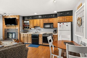A modern kitchen with wooden cabinets, a built-in oven, microwave, and refrigerator. - 'Escape Plan'  great location for year round fun (Mancelona)