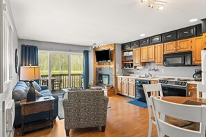 A modern kitchen with wooden cabinets, a built-in microwave, and a gas stove. - 'Escape Plan'  great location for year round fun (Mancelona)