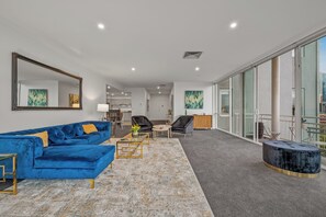 Relax in this stylish living room with a sofa, ottoman, and large mirror.