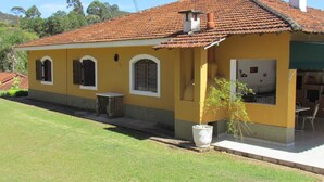 A yellow building with a tiled roof, a small porch, and a large planter. - ACHIEVING SITE Ground floor, WI FI, Heated pool option, BBQ, Ping Pong (Pinhalzinho)