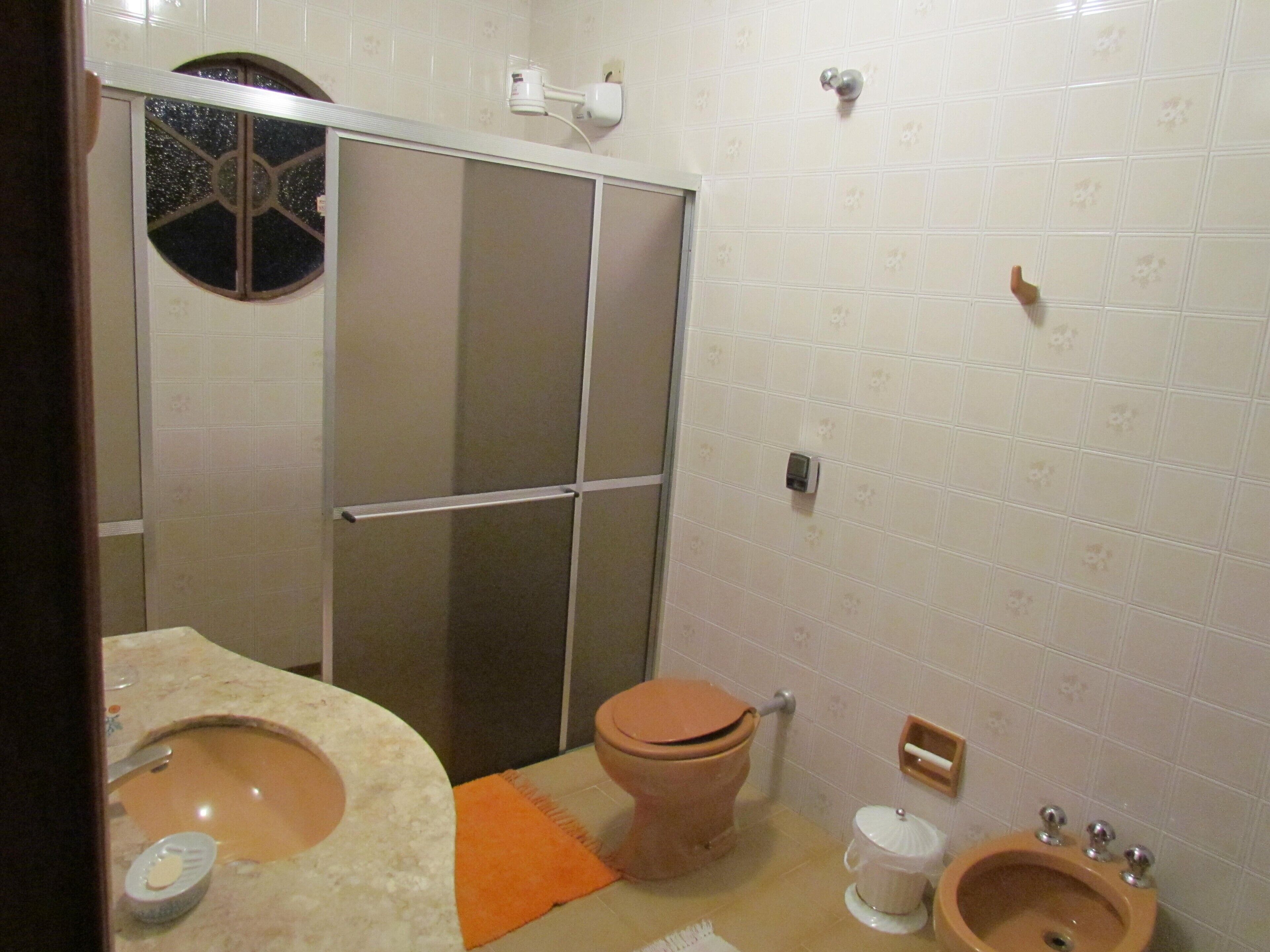 Ein Badezimmer mit Toilette, Bidet, Waschbecken und Duschbereich.