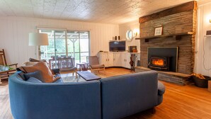 Un salon avec un canapé bleu, une cheminée et un téléviseur.