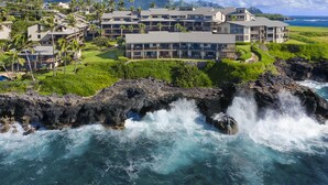 Un resort con varias construcciones, un litoral rocoso y vistas al océano.