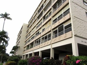 Un immeuble à plusieurs étages, doté de nombreux balcons et comprenant un garage souterrain.