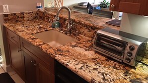 A kitchen with granite countertops, a built-in sink, and a toaster oven. - Modern, remodeled, ocean views, comfortable and convenient 580 sf (Kihei)