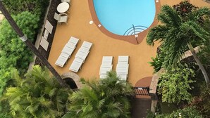 A swimming pool with lounge chairs and a lifeguard stand. - Modern, remodeled, ocean views, comfortable and convenient 580 sf (Kihei)