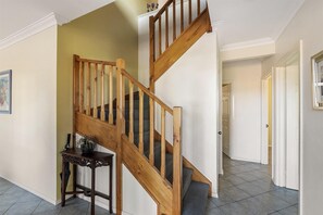A wooden staircase with a dark wooden table beside it.