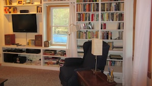 A room with a bookshelf labeled 'BARGAIN BOOKS', a television, and various board games.