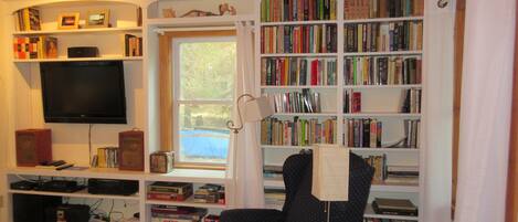 A room with a bookshelf labeled 'BARGAIN BOOKS', a television, and various board games.