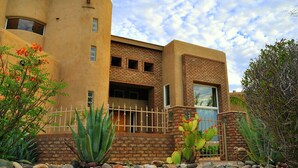 A modern building with a curved facade, a brick lower section, and a beige upper section.