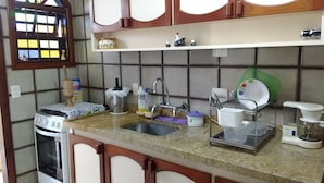 Una cocina con estufa a gas, lavaplatos y diferentes utensilios.