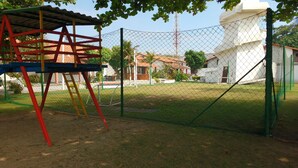 Un patio de juegos cercado con una estructura para escalar y una portería de fútbol.