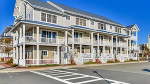 A two-story building with multiple balconies and a covered front porch.