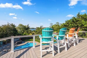 Une terrasse avec des sièges et une piscine.