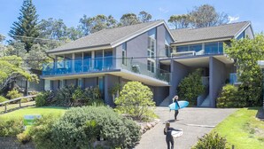 Una casa moderna de dos pisos con balcón y un espacio exterior cubierto.