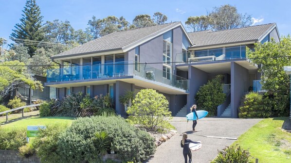 A modern two-story house with a balcony and a covered outdoor area. - Surfers Reef Escape in Mollymook (Mollymook Beach)