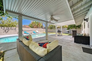 A covered outdoor area with a pool, lounge chairs, and a barbecue grill. - Your Oasis Near the Las Vegas Strip: Vacation Rental Sleeps 8 w Pool & Game Room (Las Vegas)