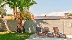 A swimming pool with lounge chairs and a solar panel on the roof.