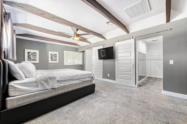 A bedroom with a bed, a TV, a wardrobe, and a ceiling fan. - Your Oasis Near the Las Vegas Strip: Vacation Rental Sleeps 8 w Pool & Game Room (Las Vegas)
