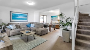 A modern living room with a sofa, coffee table, and a dining area. - Luxury Spa “Beachfront Moana”
Perfect for couples, families or friends! (Moana)