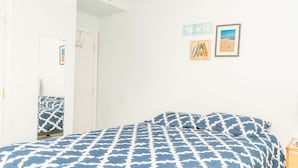 Quarto com cama, guarda-roupa e porta.